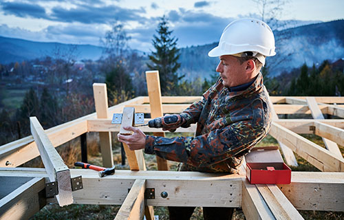 A man diligently constructs a wooden structure