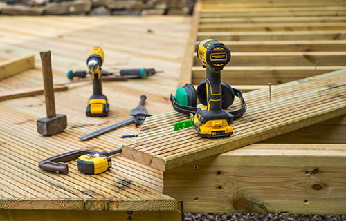 A wooden deck featuring various tools scattered across its surface