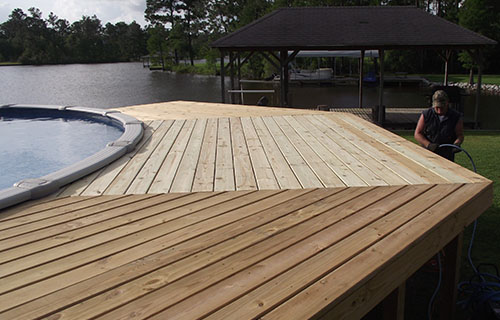 A wooden deck featuring a serene pool